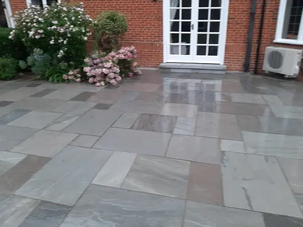 image of a large back garden, grey indian sandstone patio.