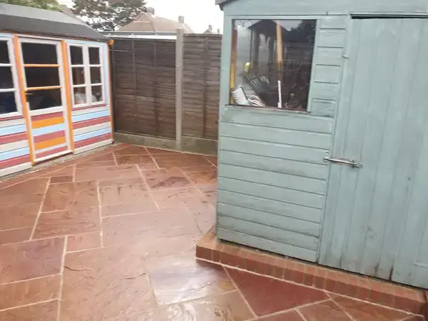 image of back garden new orange sandstone patio and wall brickwork.