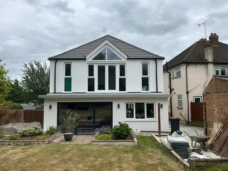 Image of large white garden house extension, walls have been rendered and painted white to match reset of the house