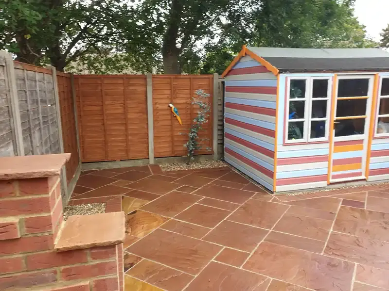 image of back garden new orange sandstone patio and wall brickwork.